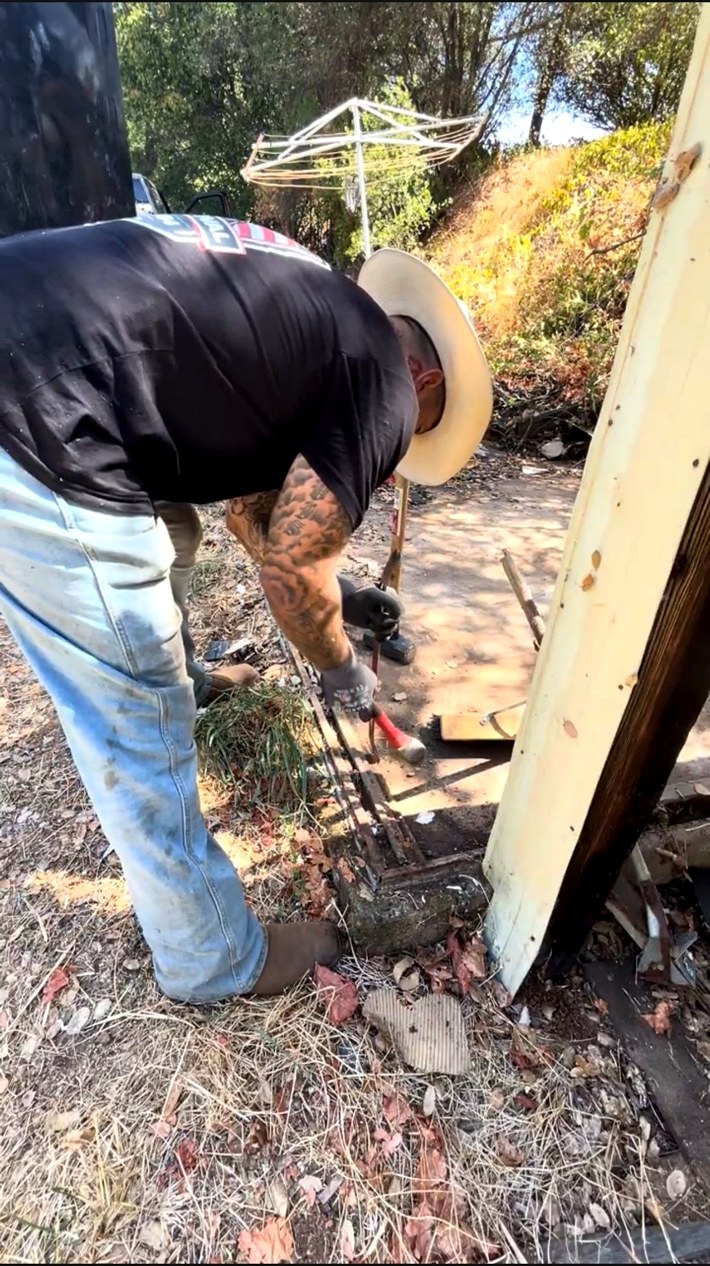 AMR Junk Removal crew breaking up concrete and removing debris by hand