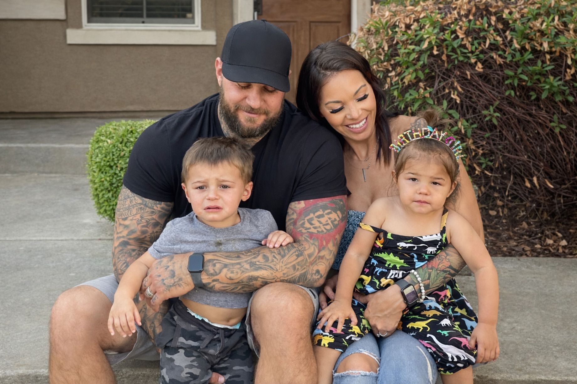 Travis Nunes with his family sitting on the front steps of their home