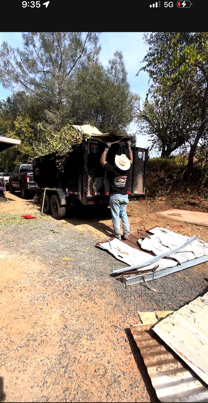 AMR Junk Removal crew loading brush and debris into the company trailer